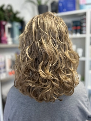 Warm blonde curls with soft dimension by Alexis